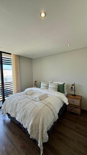 Un dormitorio con una cama grande con una ventana grande. en 37 at WildOlive, en Windhoek