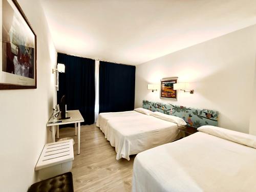 a hotel room with two beds and a table at Hotel Virrey in Arnedo