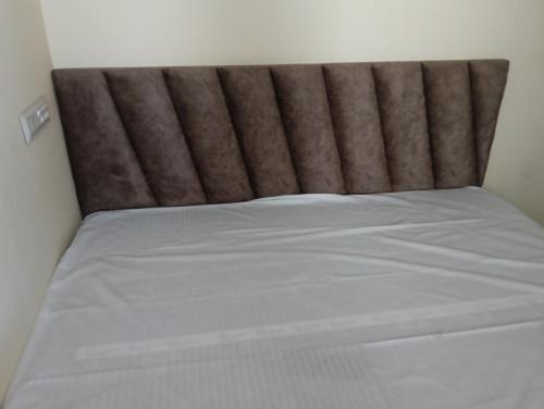 a bed with a brown headboard in a room at Luxe Shree Krishna Kunj Villa in Ujjain