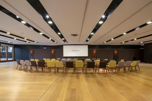 a conference room with chairs and a projection screen at Eurostars Pamplona in Pamplona