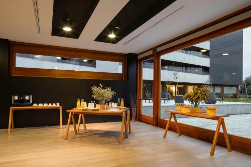a dining room with two tables and windows at Eurostars Pamplona in Pamplona