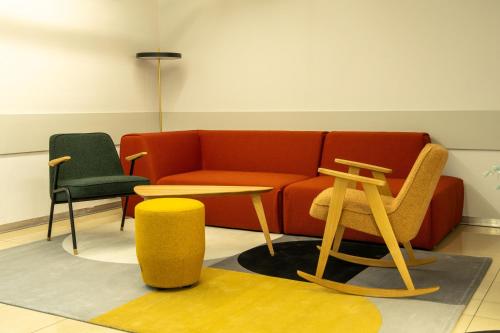 a living room with a couch and a table and chairs at Hotel Portofino in Włocławek