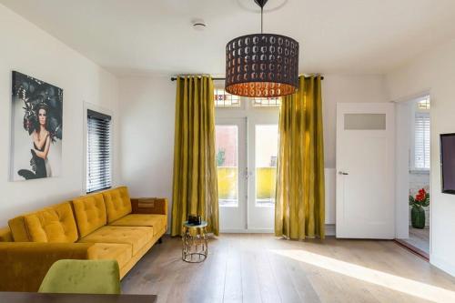 a living room with a yellow couch and yellow curtains at Eindhoven City Suites Hertogstraat C Modern 2P in Eindhoven