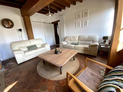 a living room with couches and a coffee table at La Ferme Verte in Montigny-Lengrain