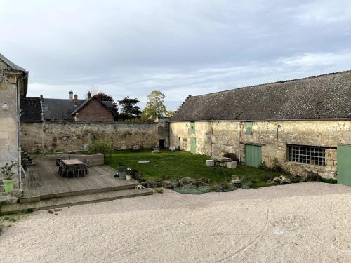a courtyard of an old stone building with a yard at La Ferme Verte in Montigny-Lengrain
