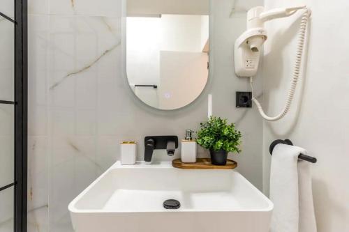 a bathroom with a white sink and a mirror at AIASTAY Bucharest River Apartments in Bucharest