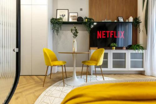 a bedroom with a table and two yellow chairs at AIASTAY Bucharest River Apartments in Bucharest