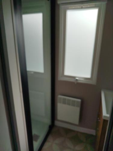 a bathroom with a window and a glass shower at MHVACANCES LOUENT PLUSIEURS MOBILHOMES DANS CAMPING 4 ETOILES PROCHE CHATEAUX et ZOO BEAUVAL in Onzain