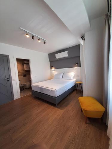 a bedroom with a white bed and a wooden floor at QonuQ Bozcaada in Bozcaada