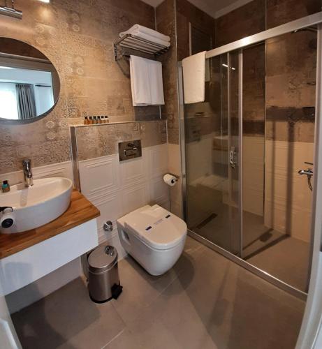 a bathroom with a toilet and a sink and a shower at QonuQ Bozcaada in Bozcaada