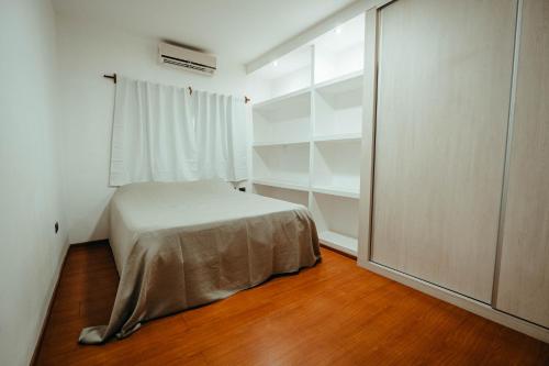 Un dormitorio con una cama y una ventana grande. en Departamentos Rosina II, en San Fernando del Valle de Catamarca