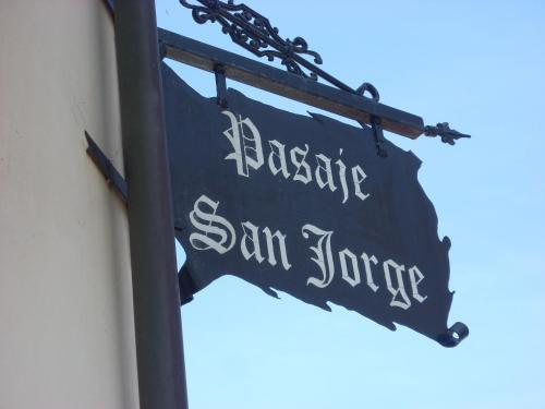 a sign that reads plastic sun dance hanging from a building at Pasaje San Jorge in Comillas