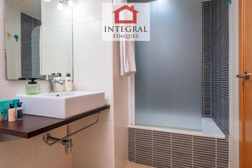 a bathroom with a white sink and a shower at Apartament Cel Blau in Palamós