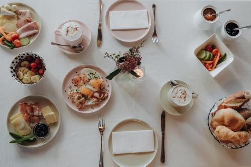 a white table with plates of food on it at Hotel Krone Großarl in Grossarl