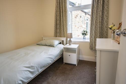 a small bedroom with a bed and a window at California Cottage in Barnard Castle