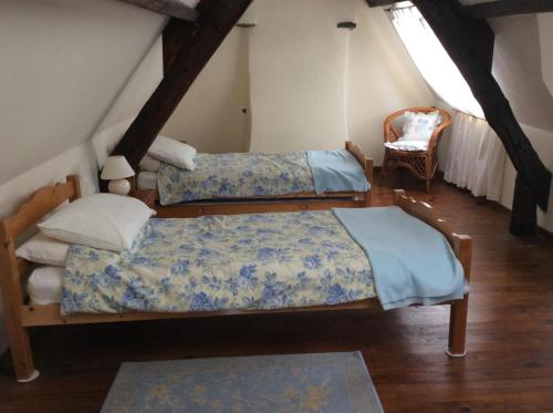- une chambre mansardée avec 2 lits et une chaise dans l'établissement Grange Cottage, à Saint-Dolay