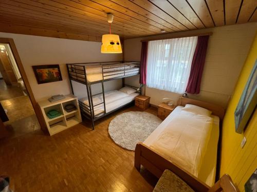 a small bedroom with a bunk bed and a window at Relaxen am Brienzersee mit Terrassen und Grill in Brienz