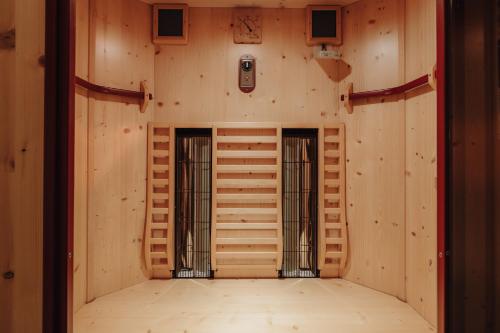 an empty room with wooden walls and two doors at Hotel Krone Großarl in Grossarl
