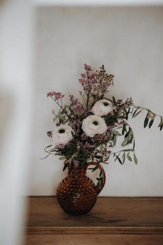 a vase with flowers in it on a table at Hotel Krone Großarl in Grossarl