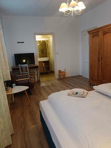 a bedroom with a bed and a living room at Wein & Landhaus Willi Opitz in Illmitz