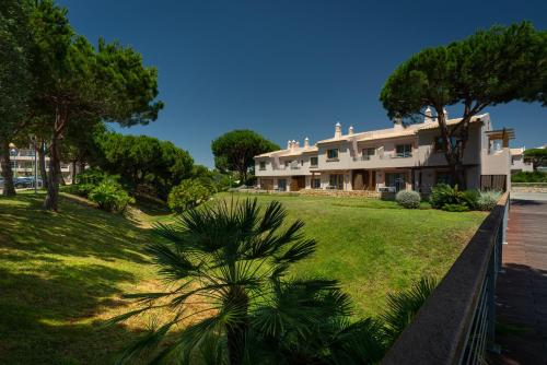 a house with a green yard in front of it at Grande Real Santa Eulalia Resort & Hotel Spa in Albufeira
