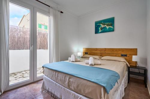 a bedroom with a bed and a large window at Villa Martin in Portocolom
