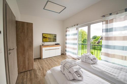 a bedroom with a bed and a large window at Baltic Village - VIP Haus in Damp