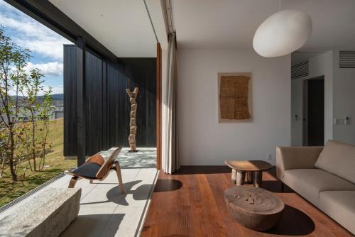 a living room with a couch and a chair at 歓宿縁 eshikoto in Eiheiji