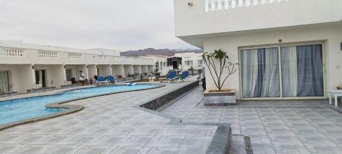 a building with a swimming pool next to a resort at Nubia Island View Dahab in Dahab