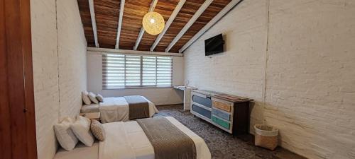 a room with two beds and a television in it at Rústic Quinta La Aurora in Baños
