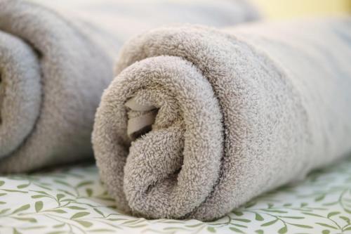 - une pile de serviettes de toilette sur le lit dans l'établissement L'escale des copains, au Barcarès