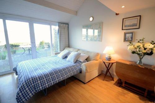 a bedroom with a bed and a couch at Steepfield Studio in the heart of Bantham Village in Bigbury on Sea