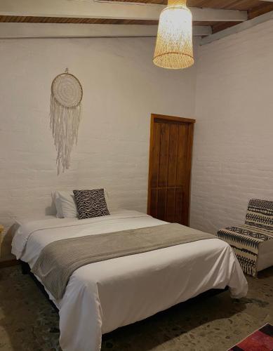 a bedroom with a bed and a chandelier at Rústic Quinta La Aurora in Baños