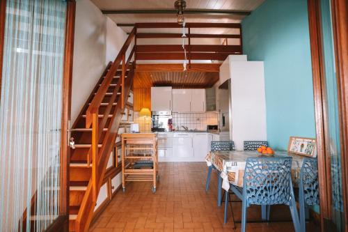 une cuisine avec un escalier, une table et des chaises dans l'établissement L'escale des copains, au Barcarès