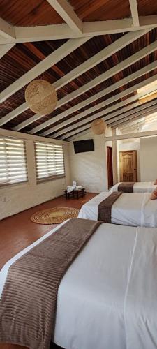 a bedroom with two beds and a flat screen tv at Rústic Quinta La Aurora in Baños