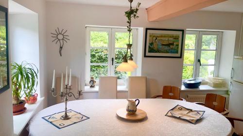 comedor con mesa y algunas ventanas en Kamin Ofen Wohnung -Altes Landhaus Oste- 2 Schlafzimmer, Terrasse, Grill, Küche, Bad, WLAN, nah am Nordsee Strand, en Hemmoor