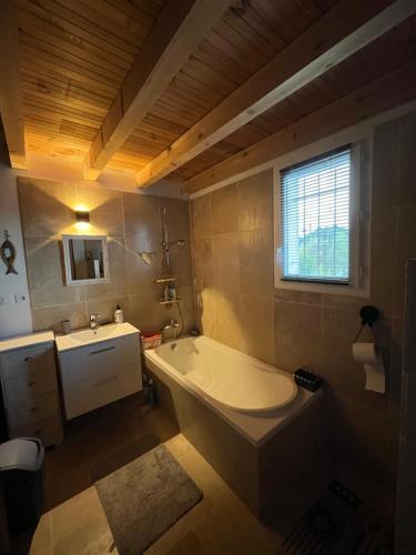 La salle de bains est pourvue d'une grande baignoire et d'un lavabo. dans l'établissement Villa de charme 130 m2, à Vidauban
