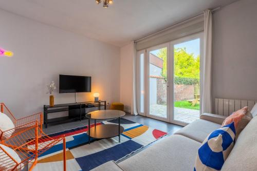 un salon avec un canapé et une télévision dans l'établissement Maison 3 chambres avec jardin, proche métro, à Croix