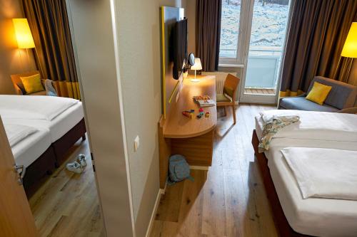 a hotel room with two beds and a television at ROBINSON Landskron in Landskron