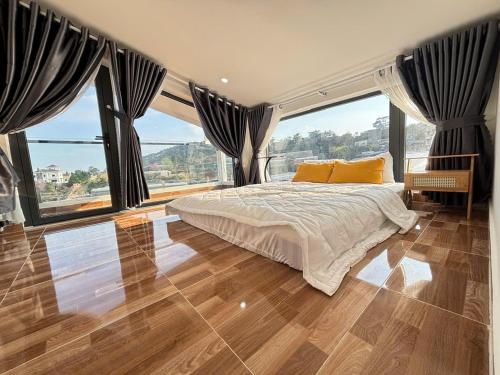 a bedroom with a large bed and large windows at Villa Healing Home - Hồ Bơi Nước Nóng in Trai Mat