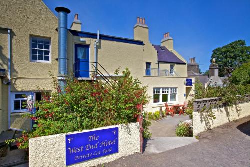 a house with a blue sign in front of it at West End Guest House in Kirkwall