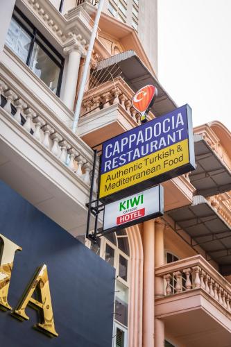 a sign for a restaurant on the side of a building at Kiwi Capsule Hotel in Bangkok