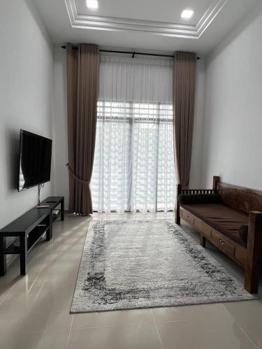 a living room with a couch and a large window at Syakila Homestay in Marang