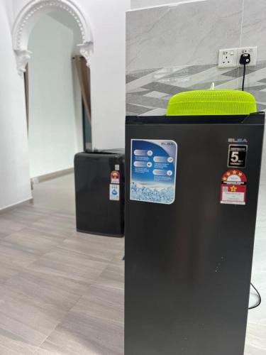a black refrigerator with stickers on it in a room at Syakila Homestay in Marang