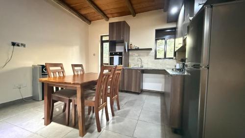 a kitchen with a table and chairs and a refrigerator at Lush Urbarn Oasis in Kampala