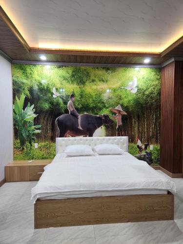 a bedroom with a painting of a man on a horse at New Life Homestay in Phan Thiet