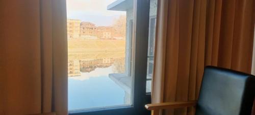 a room with a window with a view of the water at zoz Jhelum river in Srinagar