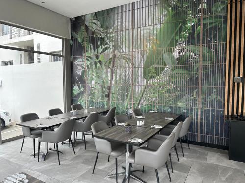a restaurant with tables and chairs and a large window at The Capital on Bath in Johannesburg