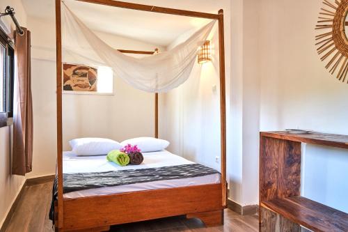 a bedroom with a canopy bed with flowers on it at Chambre double vue mer in Mar Lodj