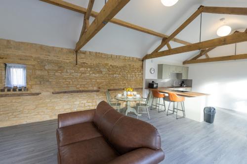 a living room with a couch and a table at Hedgehogs Home at Tove Valley Cottages in Towcester